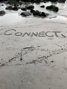 The word Connect written in the sand.